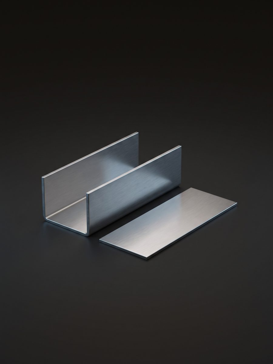 A bent steel U-profile beside its flat blank, 3D render