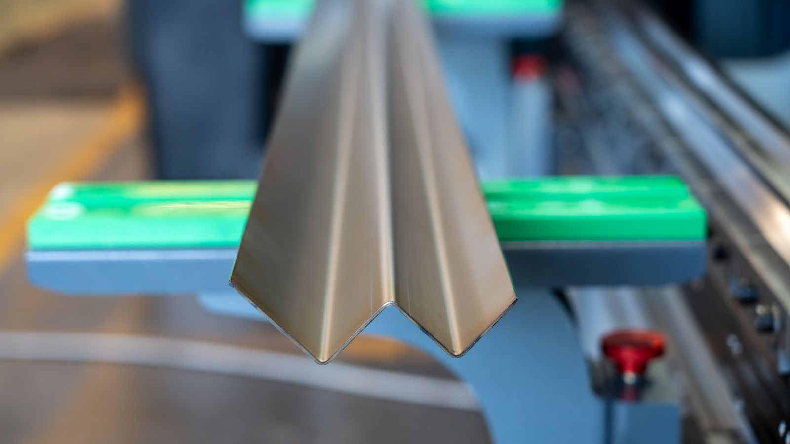 A multi-bend stainless profile resting on the front supports of a Genius PLUS X